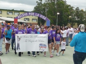 The survivors, with dark purple t-shirts,  in the Survivors Lap (Victory Lap).  They start the Relay for Life celebrating the fight aginst cancer..
